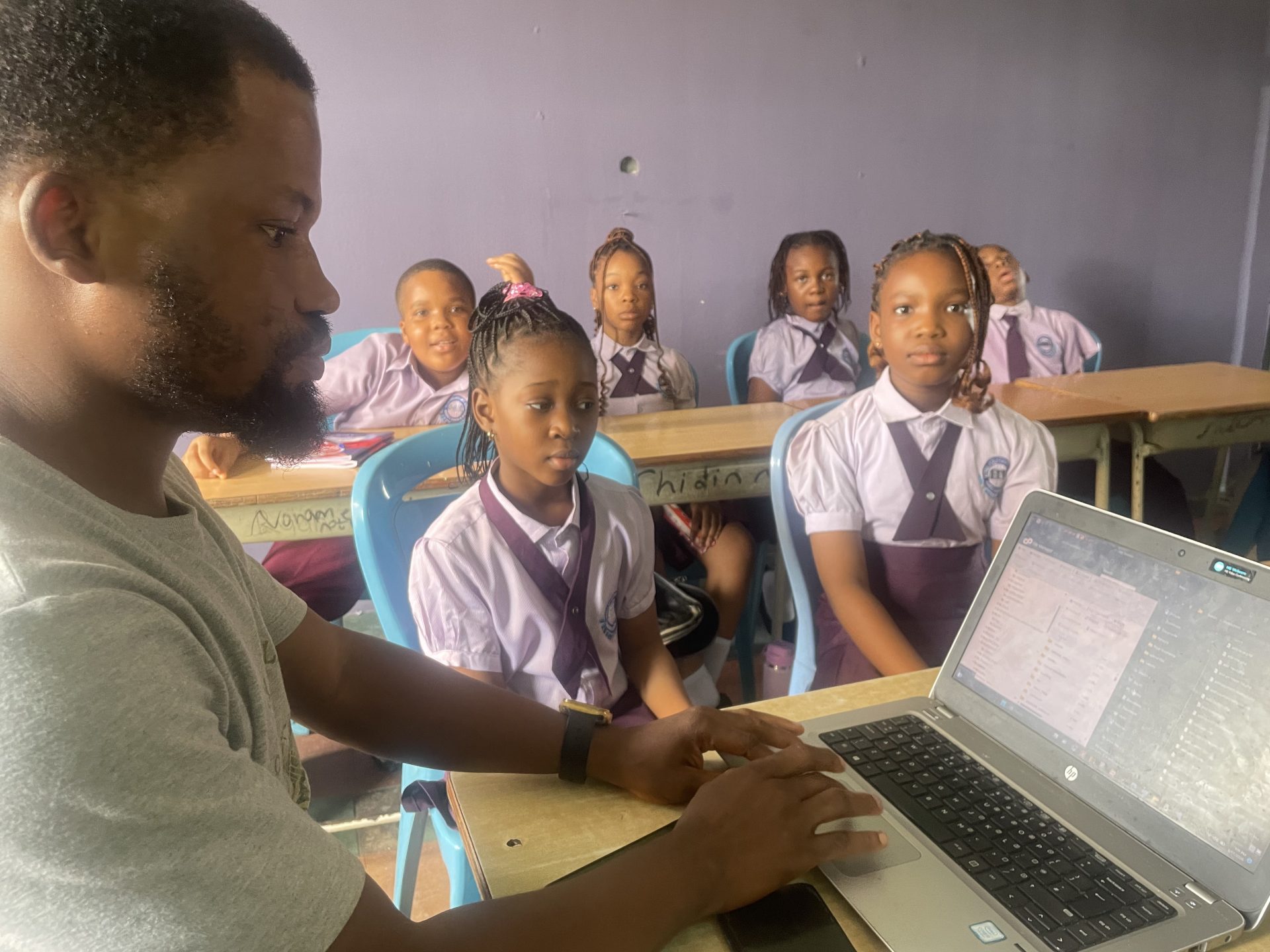 A teacher introducing pupils to computer literacy at Royal Excellentia International School